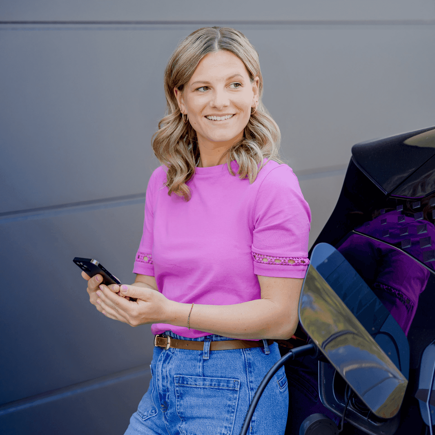 Kundin freut sich ihr Auto mit günstigem Strom zu laden