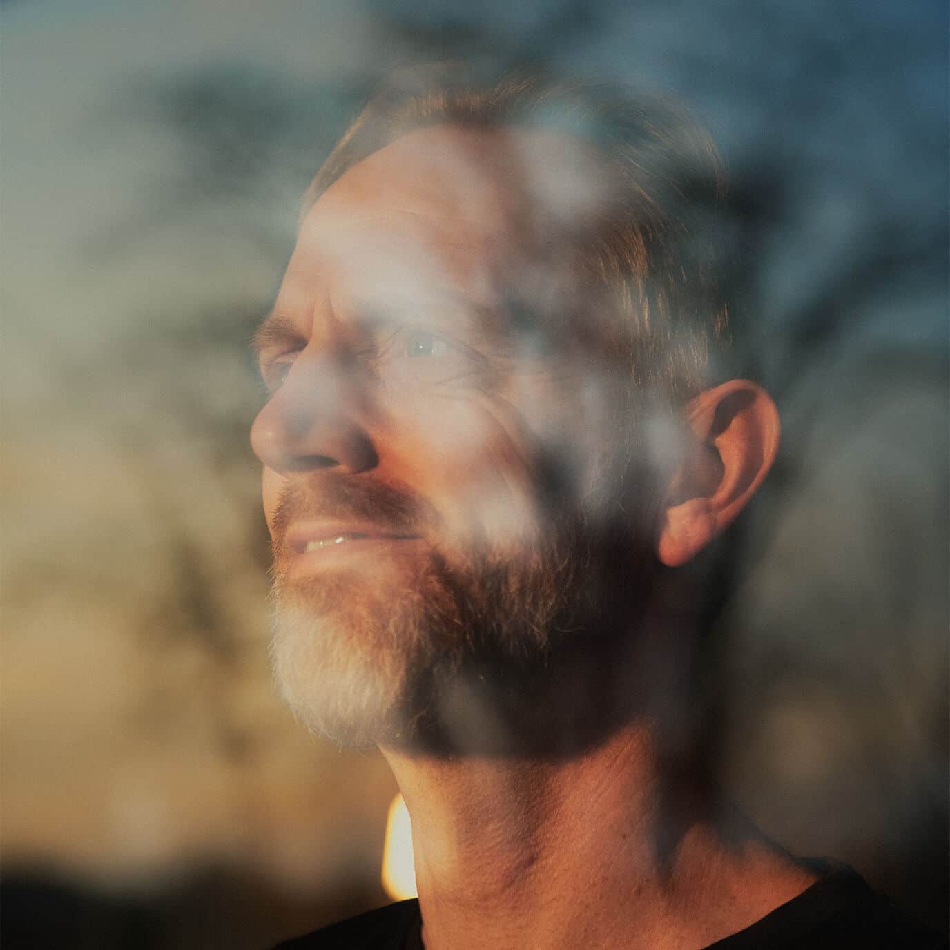 Mand i vindue med sollys i ansigtet